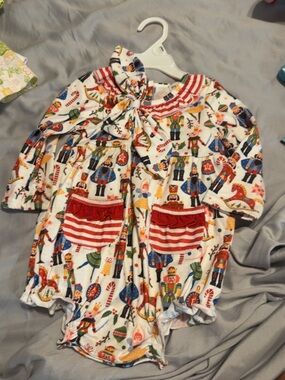 Holiday Nutcracker Print Baby One-Piece Footie with Red Pocket Accents